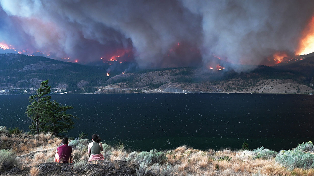 A thick layer of smoke emanates from forest fires on the west side of Okanagan Lake.