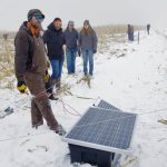 Tour attendees check out Brett McRae’s solar fencing system during a January 2024 field tour.