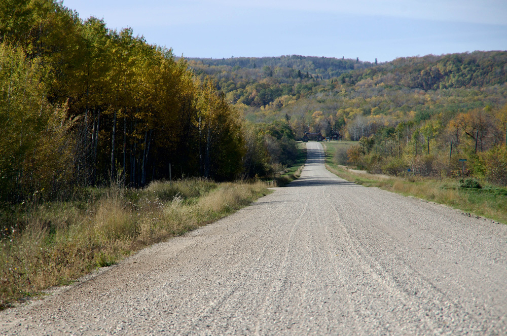 A gravel road leading into Riding Mountain National Park in western Manitoba.