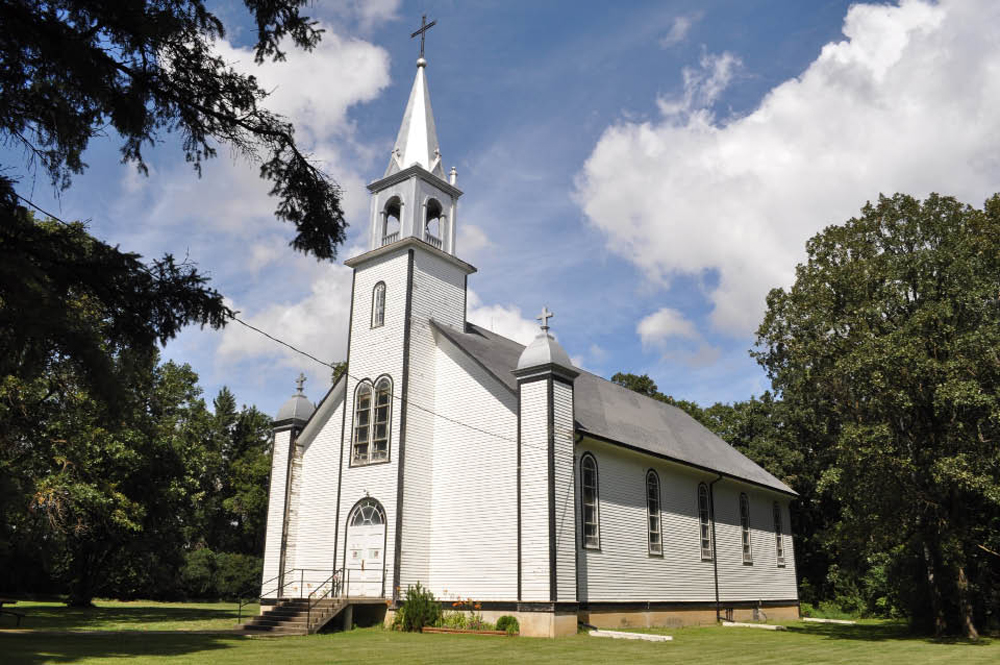 St. Lupicin Roman Catholic Church features well-treed grounds.