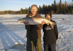 Tim Sopuck and Devin Borus pose with a pike they took through the ice on a large dead bait.