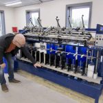 Bryan Driedger demonstrates spinner operation at the April grand opening of the Austin Woollen Mill.