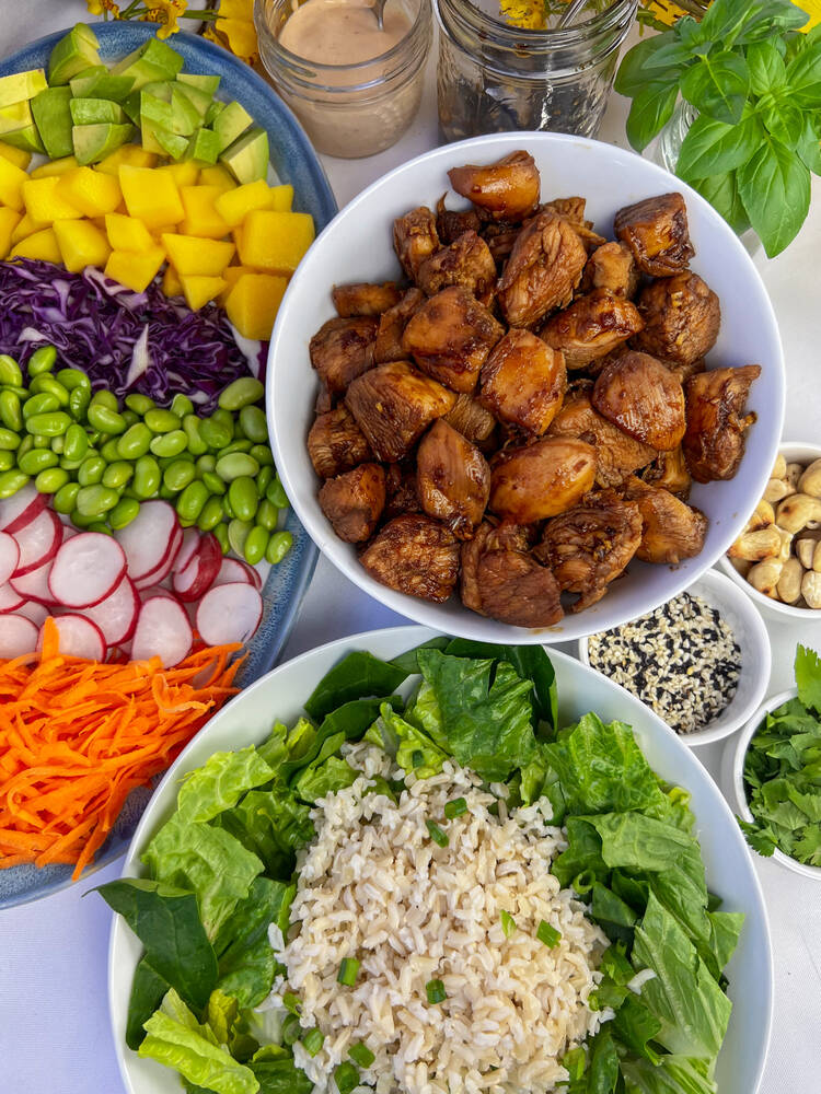 Chicken Teriyaki bowl ingredients, including chicken, radishes, sliced carrots and edamame beans.