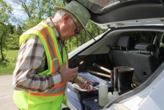 Ken Boese strains a water sample into a bottle to be tested for phosphorus content.