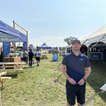 Kyle Gibson of AGI3 outside his company's booth at Ag in Motion