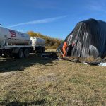 Anhydrous ammonia is injected into a pile of low-quality forage. The black side of the tarp is turned outwards to better warm the contents and speed up the process.