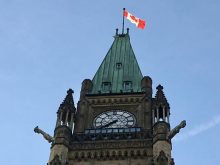 A Canadian flag flies at the top of one of the Parliament buildings in Ottawa. 