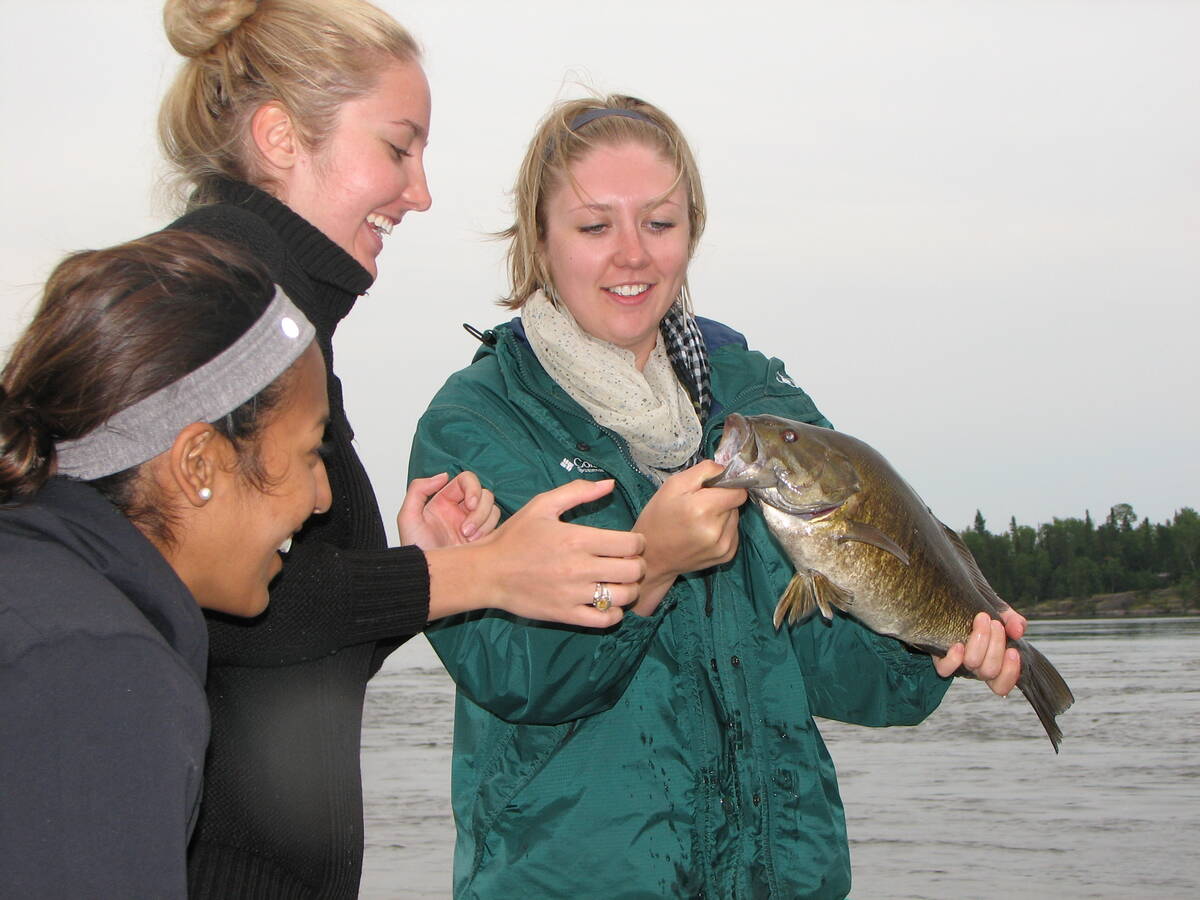 Kate Sopuck (centre) admires her first Master Angler smallmouth bass, caught on a slip bobber. Photo: Tim Sopuck