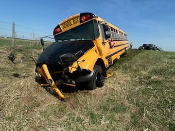 A damaged school bus rests in the ditch after colliding with a tractor on a rural road in Manitoba May 13, 2025.