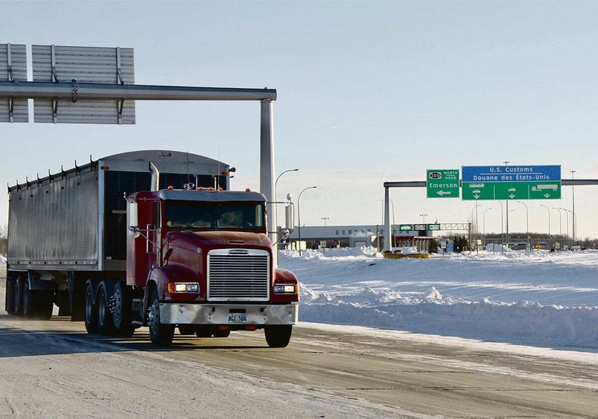 A semi truck hauls cargo on a highway in Western Canada.