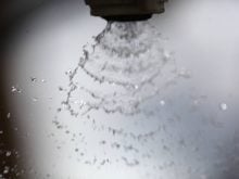 An extreme close-up of the fan-like pattern created by droplets leaving the nozzle of a sprayer. Photo: Michael Robin