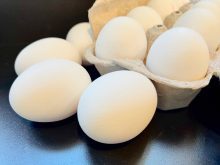 Eggs are piled around a carton of Canadian eggs.