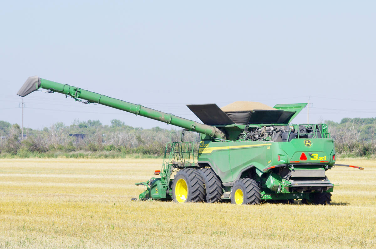 A loaded combine waits to be unloaded and the grain taken to be stored during harvest last year near Winkler, Man. Photo: File