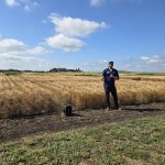 Ducks Unlimited Canada's Alex Griffiths stands in front of a field of winter wheat at the Manitoba Crop Diversification Centre in Carberry on Aug. 6, 2025.