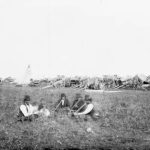 Antique photograph of a Metis traders' camp in 1879 with Red River carts in background. Dr. Robert Bell/Library and Archives Canada/PA-039926