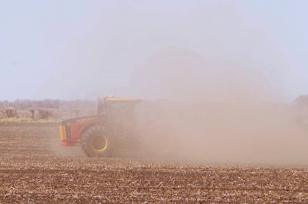 a red tractor obscured in dust while working in dry soils. Pic: Alexis Stockford
