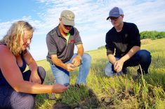 Clayton Robins (centre) shows off the soil health gains he's made through changing his on-farm practices during a 2019 field tour on his western Manitoba farm.