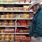 Michael Lipsitz picks out a package of hot dogs while grocery shopping at the WalMart in Crossville, Tennessee March 21, 2008.  Food prices are soaring, a wealthier Asia  is demanding better food and farmers can?t keep up. In short, the world is in a food crisis that is in danger of boiling over.    REUTERS/Brian Snyder    (UNITED STATES)