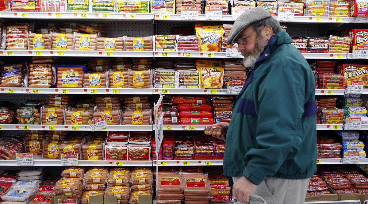 Michael Lipsitz picks out a package of hot dogs while grocery shopping at the WalMart in Crossville, Tennessee March 21, 2008.  Food prices are soaring, a wealthier Asia  is demanding better food and farmers can?t keep up. In short, the world is in a food crisis that is in danger of boiling over.    REUTERS/Brian Snyder    (UNITED STATES)