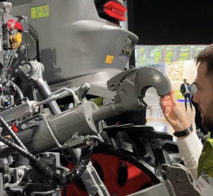 Vasily Badya, Claas product manager for Axion tractors, demonstrates how it only takes two fingers to raise or lower the heavy top link on the Axion 9.450 tractor. The near effortless task is achieved by a weight compensator mechanism.  Photo: Greg Berg
