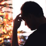Sad on Christmas. Unhappy, lonely or tired man with stress, grief or depression. Family fight, loneliness, frustration or money problem on Xmas. Sick person with flu, pain and headache on holiday. Tero Vesalainen/iStock/Getty Images