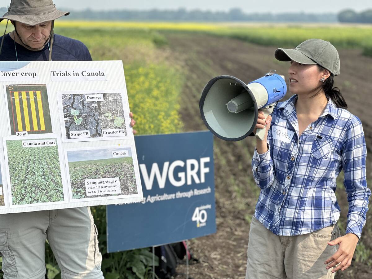 University of Manitoba graduate students Aleksander Zashev and Raquel Chinchin Talavera, members of Alejandro Costamagna&rsquo;s entomology lab, walk farmers through the study&rsquo;s results at the U of M field day in Carman. Photo: Don Norman