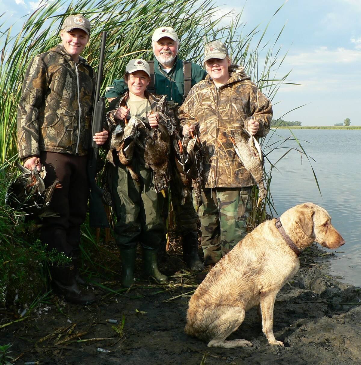 Young hunters beam after a successful mentored hunt. The old retriever, meanwhile, acts like he&rsquo;s seen it all before. Photo: Tim Sopuck