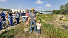 Kelsey Sunaert speaks to farm tour attendees beside a now-empty irrigation reservoir built on his Deloraine-area farmyard in 2023. Photo: Geralyn Wichers