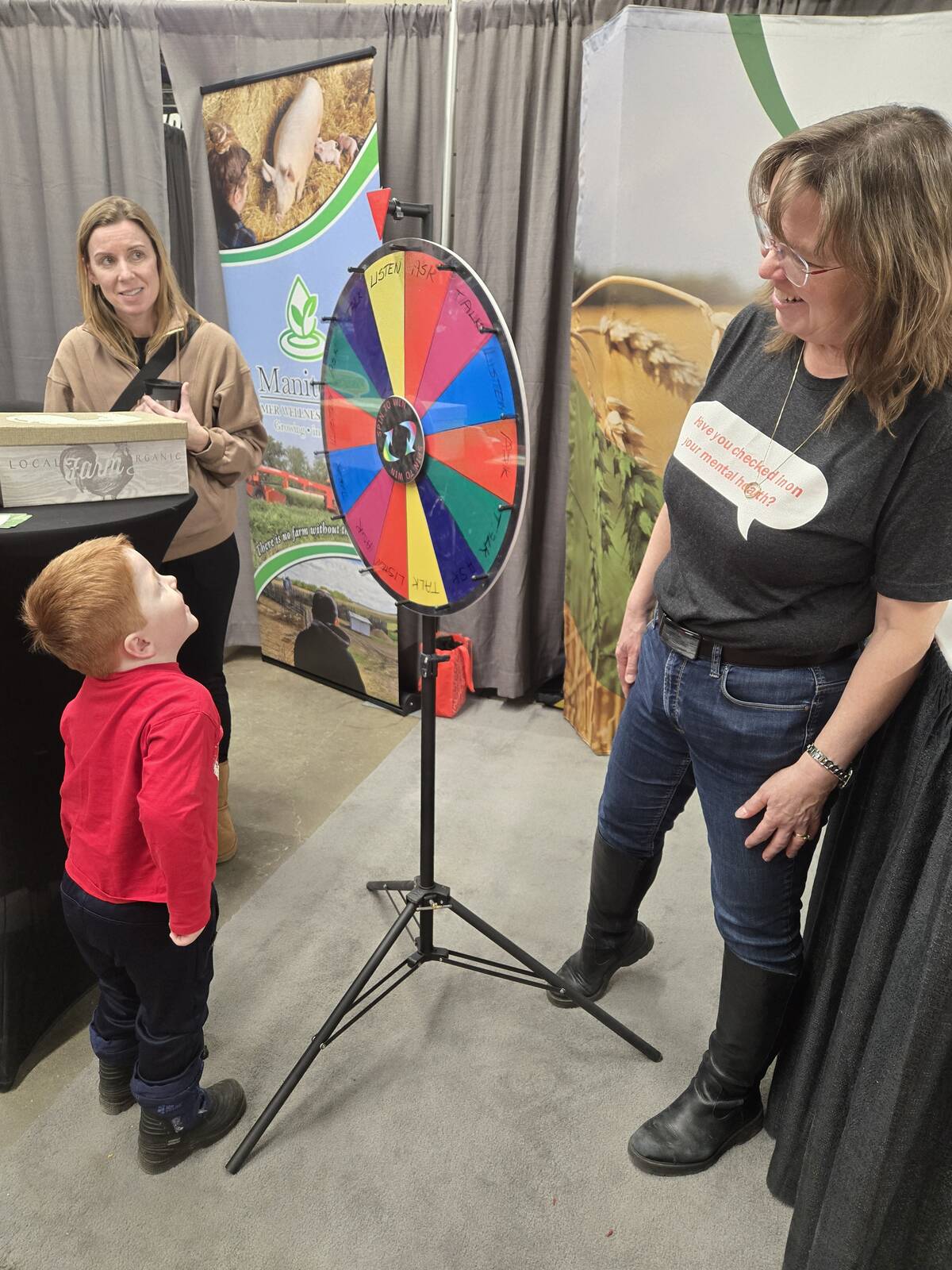 The Manitoba Farmer Wellness Program booth was a popular spot at the 2026 Manitoba Ag Days in Brandon. Counsellor Tracy Young (left) and Merle Massie, executive director of The Do More Agriculture Foundation, which supports the program, chat with a young visitor to the booth on Jan. 22. Photo: Miranda Leybourne