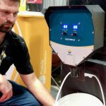 Chris Hendrickson with Prairie Grain Analyzers runs a grain sample through the Auger Sampler device at Manitoba Ag Days.  Photo: Greg Berg