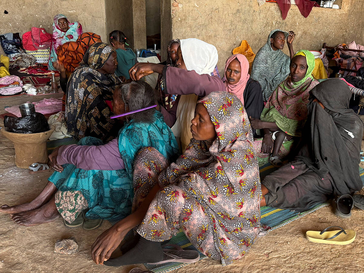 A displaced woman from Dalanj braids her grandmother's hair at a displacement registration center in El Obeid, North Kordofan State, Sudan, January 15, 2026. REUTERS/El Tayeb Siddig