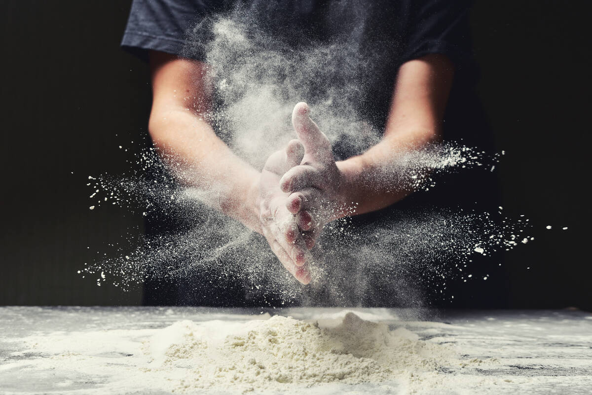 Clap hands of baker with flour in restaurant kitchen. YaroslavKryuchka/Getty Images