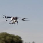 The DJI Agras T100 drone flies through the air during a demonstration at Canada&rsquo;s Outdoor Farm Show in Woodstock, Ont. Photo: Greg Berg
