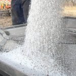 Granular urea fertilizer pours through a screen during spring application as Middle East conflict disrupts global fertilizer supply and drives up prices for Prairie farmers. Photo: file