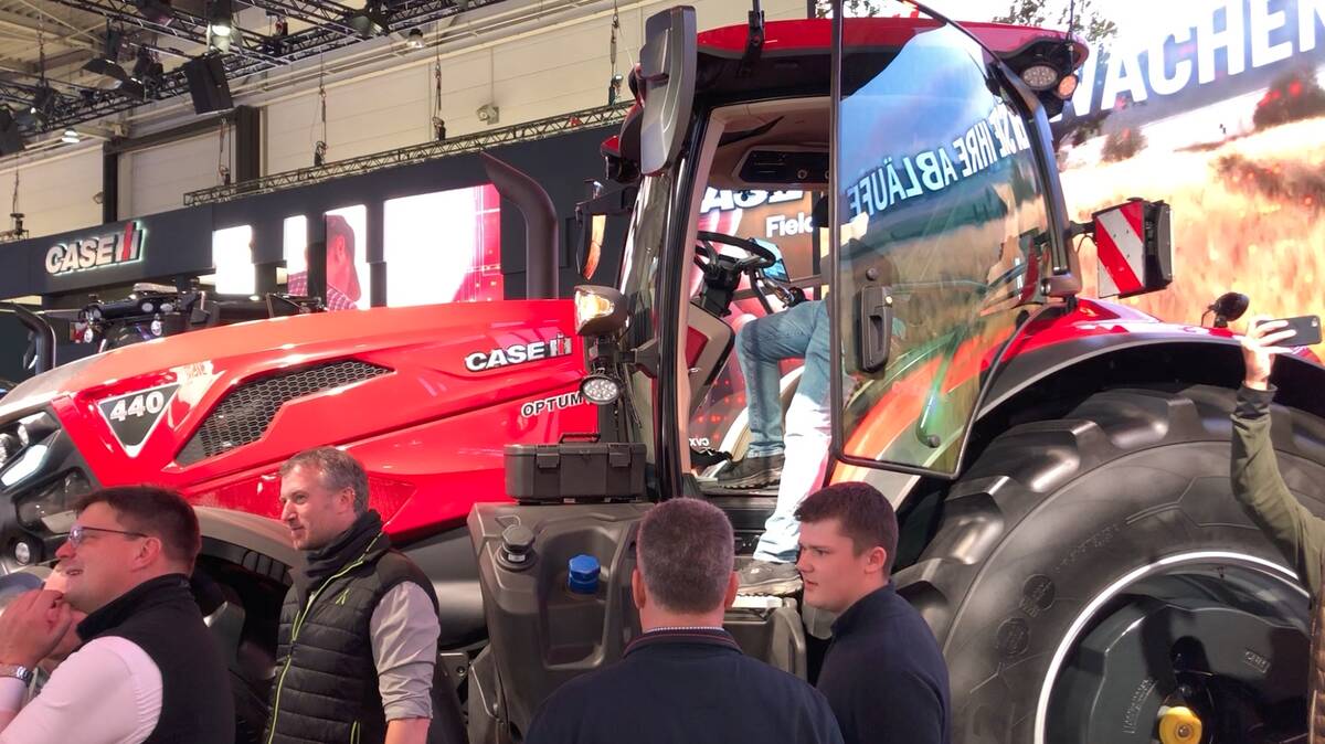 A red Case IH Optum 440 tractor draws a crowd on the Agritechnica show floor in Germany, where the redesigned lineup made its world debut in November 2025.