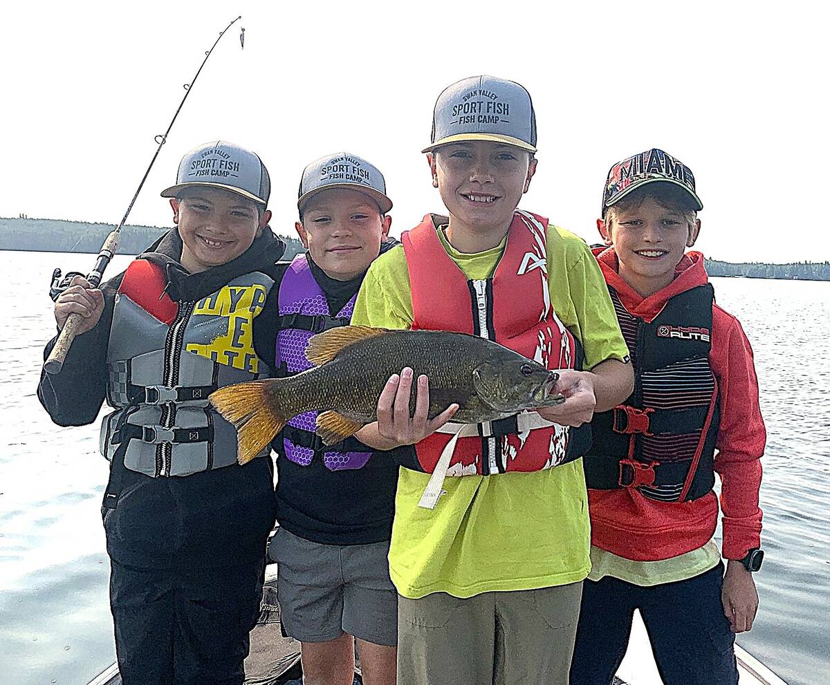 Happy kids at a SVSFE fishing day camp with a fish they've caught.