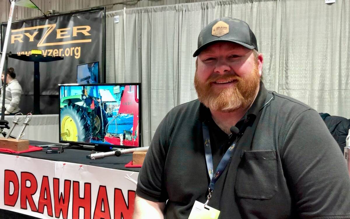 Kurtis Howardson smiling at a trade show booth with The Drawhand display behind him. Photo: Greg Berg