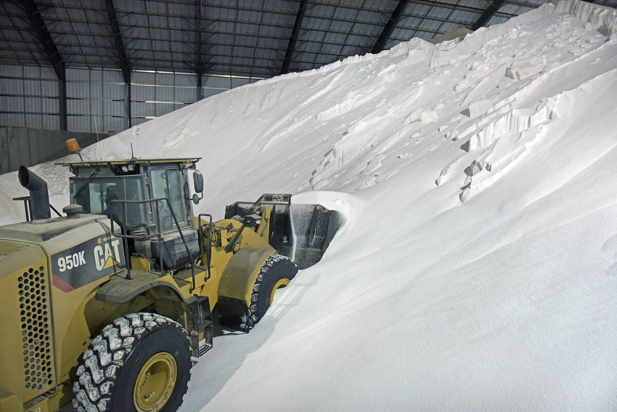 A front-end loader moves through a massive pile of urea fertilizer inside a storage facility as North American prices trend higher. Photo: file