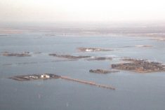 Aerial view of widespread flooding near Rosenort in May 2022, shows farm buildings, a grain elevator and communities surrounded by floodwater stretching to the horizon. Photo: Allan Dawson